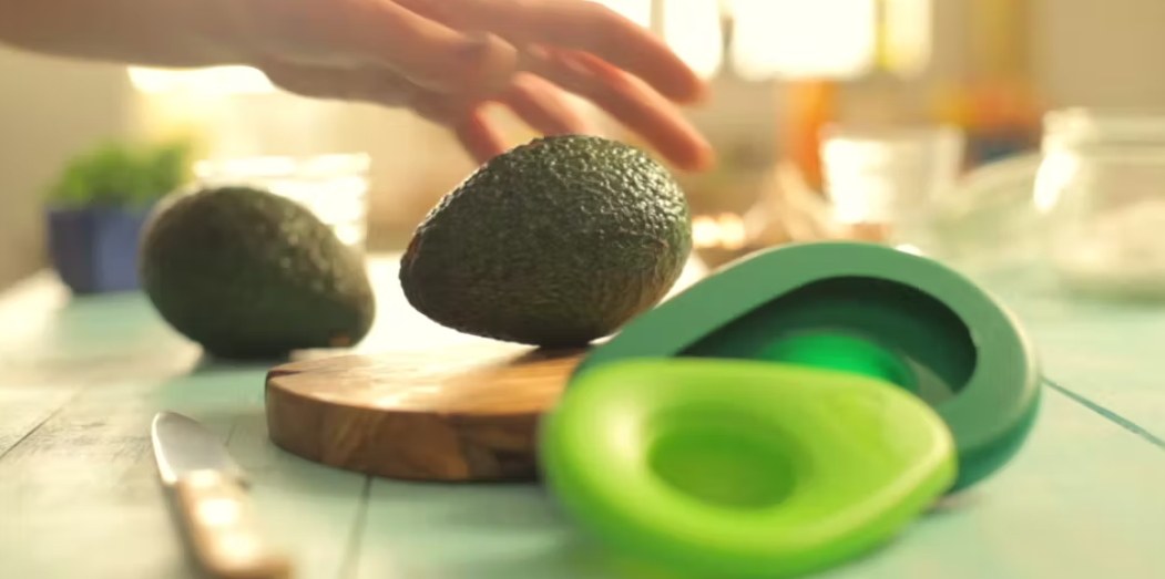 Load video: Leftover avocados are saved in Avocado Huggers, reusable silicone avocado savers. The avocado halves and their silicone covers are placed in the fridge to prevent the avocado from browning.